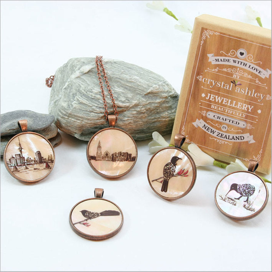 Elegant Circle Pendant Necklace featuring filigree Tui design on mother of pearl, complete with 75cm chain and gift box.