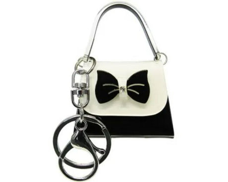 Mini acrylic handbag keyring with black and white bow, 5cm W x 7cm H, perfect for fashion-forward individuals.
