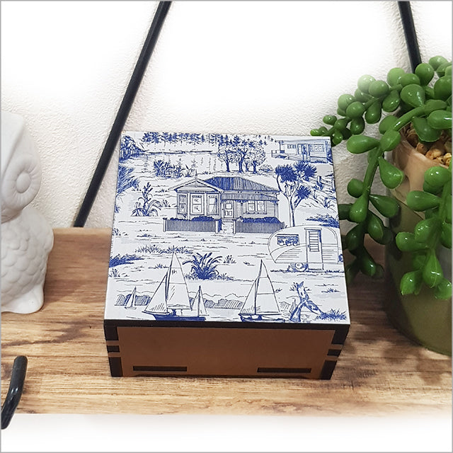 Small square trinket box featuring a villa landscape design on sustainable NZ Rimu and Pine veneer, 80mm x 80mm x 40mm.