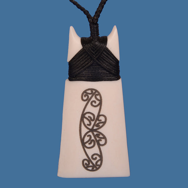 Handcrafted Bone Toki pendant with lasered Kowhaiwhai design on adjustable black cord, symbolizing strength and resilience.