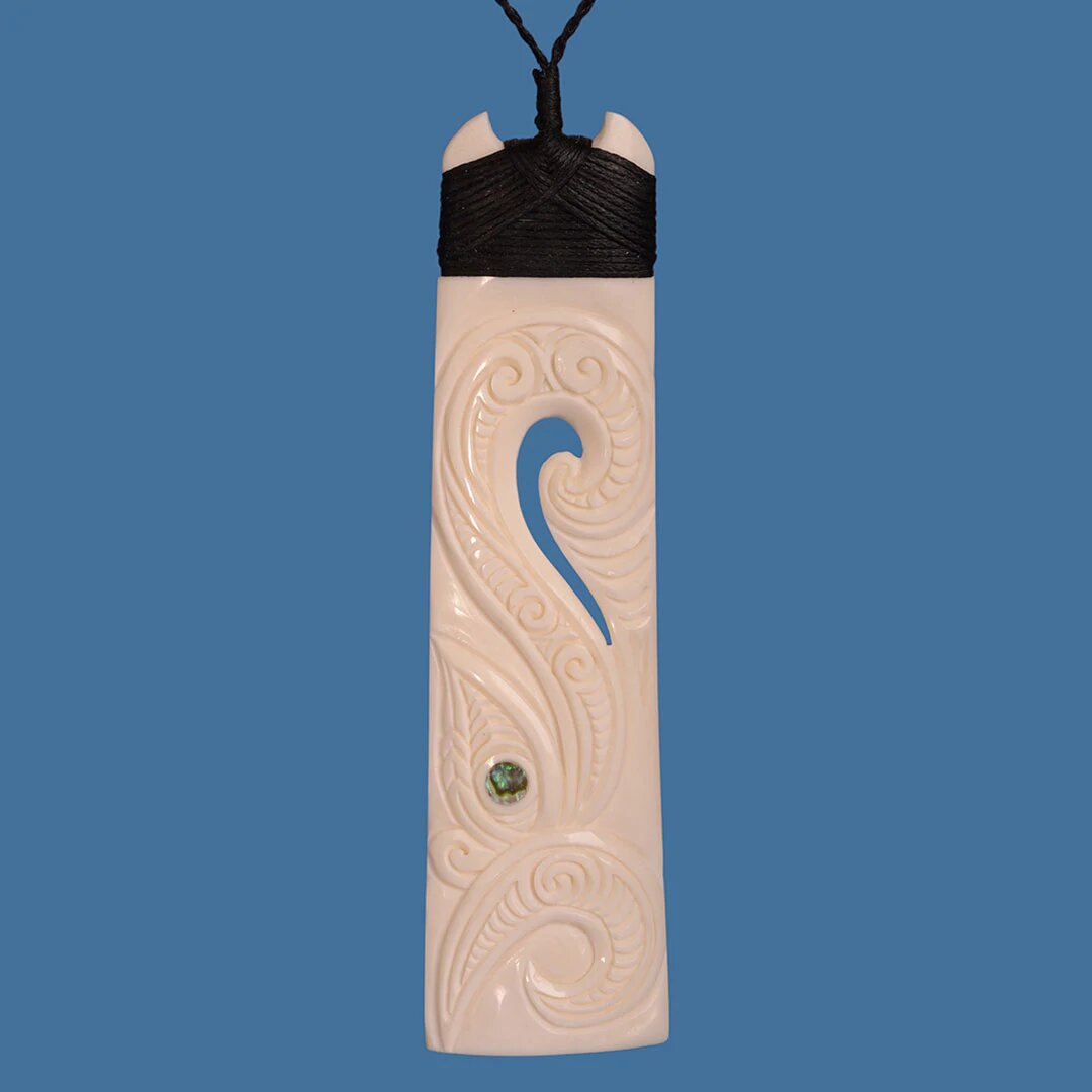 Bone Toki pendant with Manaia design, blending Maori culture with modern elegance on a black adjustable cord.