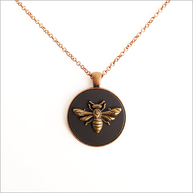 Vintage Honey Bee Circle Necklace on a black acrylic base with antique copper finish, featuring a 30mm pendant and 75cm chain.