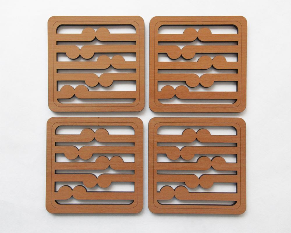 Set of four Rimu wood coasters featuring intricate koru patterns, embodying New Zealand craftsmanship and kiwiana charm.