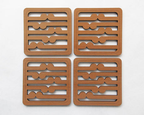 Set of four Rimu wood coasters featuring intricate koru patterns, embodying New Zealand craftsmanship and kiwiana charm.