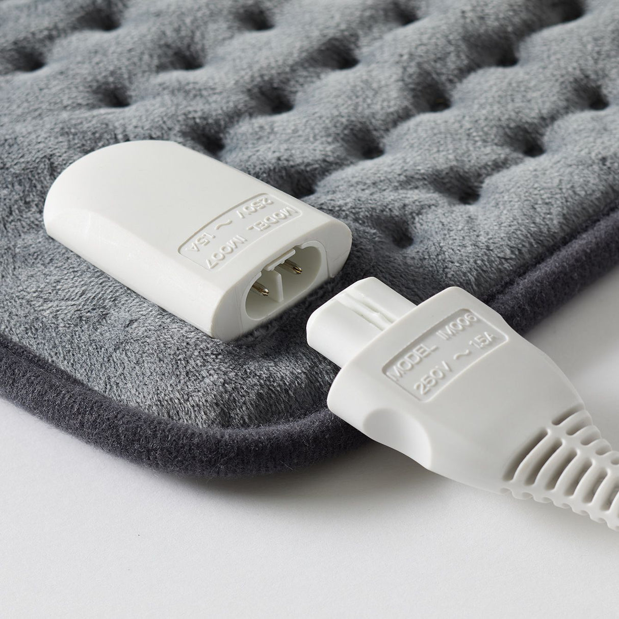 Sunbeam HPM5000 heating pad in grey, designed for soothing muscle relief with adjustable heat settings and automatic shut-off.