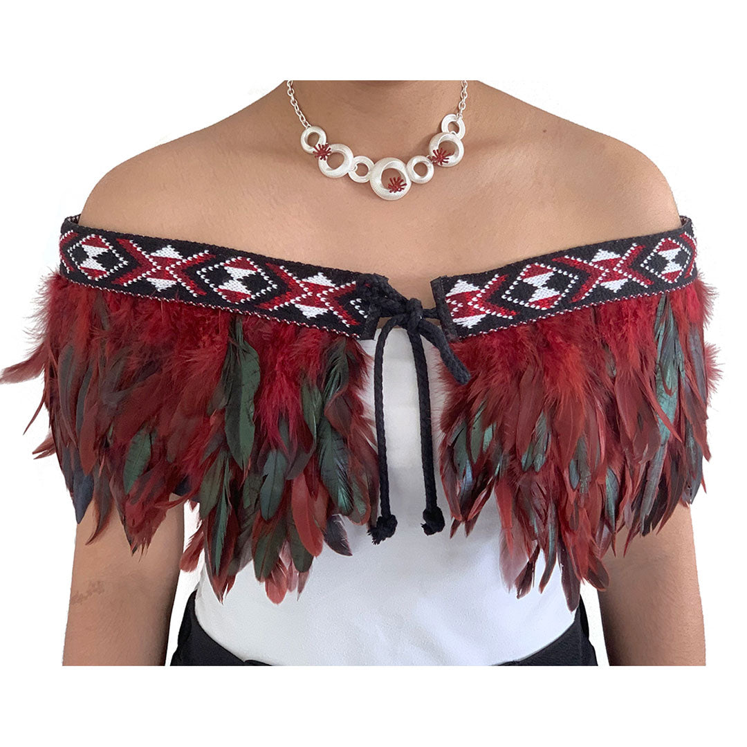 Elegant maroon Korowai Cape with feather detailing, adjustable tie, and traditional NZ wool trim, blending culture and style.