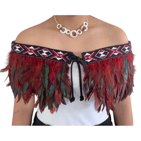 Elegant maroon Korowai Cape with feather detailing, adjustable tie, and traditional NZ wool trim, blending culture and style.
