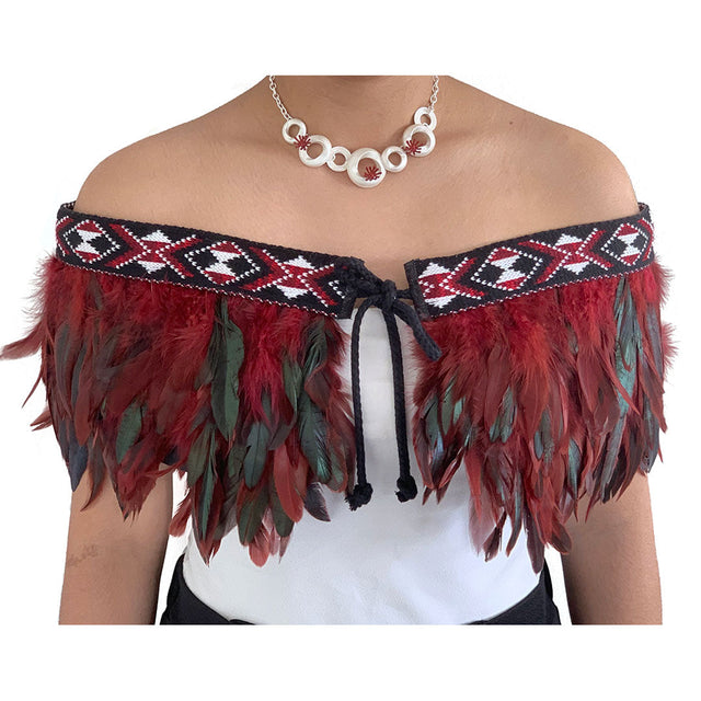 Elegant maroon Korowai Cape with feather detailing, adjustable tie, and traditional NZ wool trim, blending culture and style.