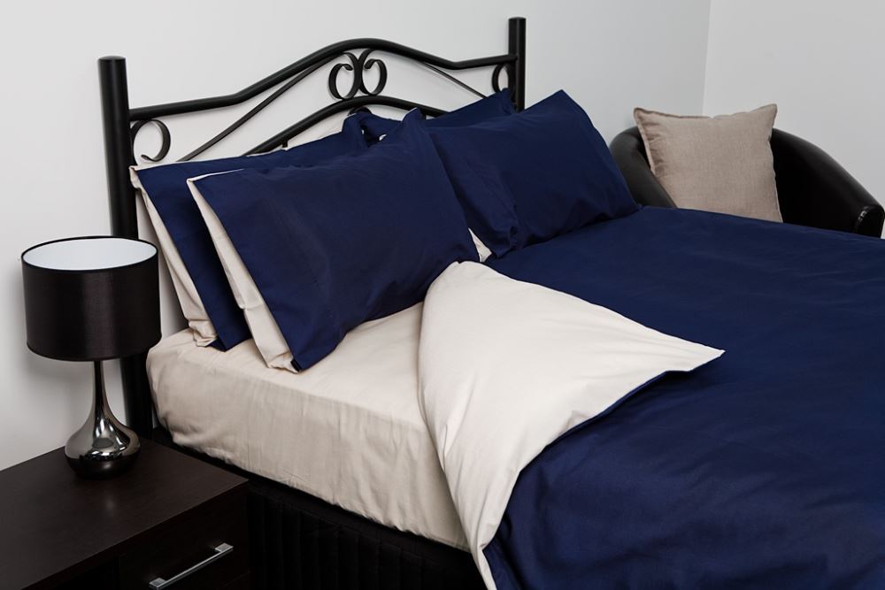 King duvet cover set in reversible blue/oyster, featuring soft, durable fabric and two matching pillowcases for luxury and style.
