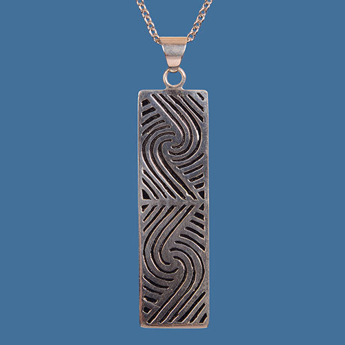 Handcrafted Maori design pendant in brass with silver plating, showcasing New Zealand's cultural heritage.