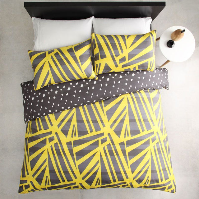 Single duvet cover set in spliced yellow with matching pillowcase, featuring a reversible print and yellow cord piping.