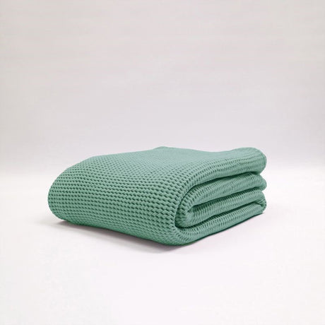 Teal stonewashed blanket by Baksana, 100% cotton, featuring a deep waffle texture, perfect for adding cozy style.