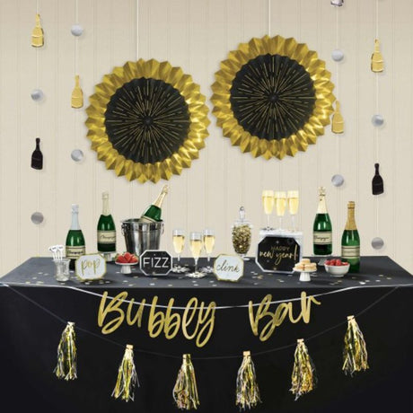 Celebrate New Year with a glamorous black, silver, and gold bubbly bar kit featuring banners, fans, and drink markers.