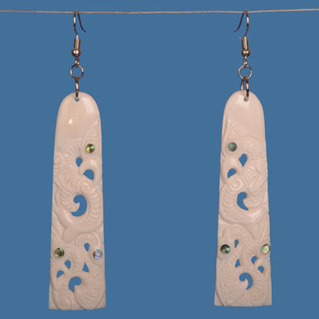 Handcrafted Triple Manaia Bone Earring showcasing paua shell accents, symbolizing protection and cultural heritage.