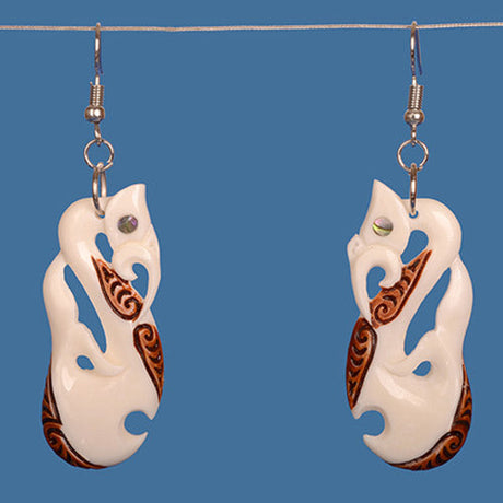 Handcrafted Manaia bone earrings with unique stain and paua shell inlays, symbolizing protection and personal growth.