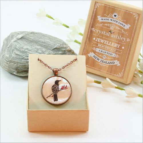 Elegant circle pendant necklace featuring filigree tui design on mother of pearl with 75cm adjustable chain.