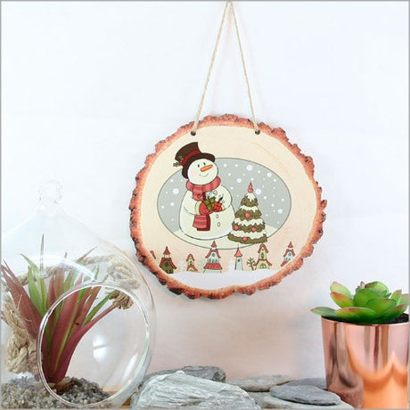 Whimsical snowman scene on a wood slice, perfect for holiday decor and adding a rustic touch to any room.