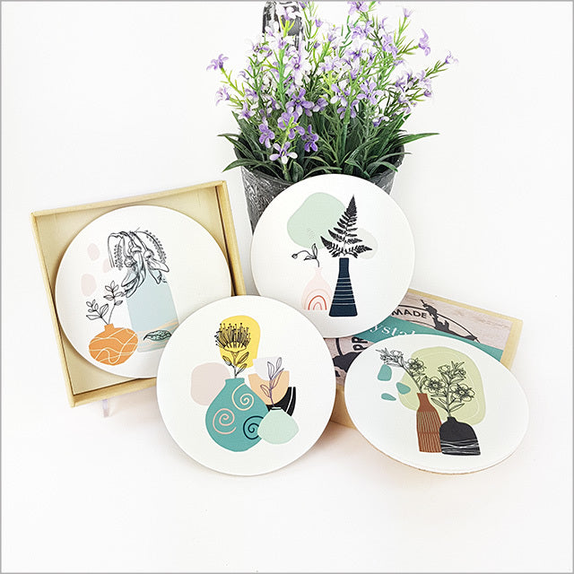 Set of coasters featuring vibrant printed NZ native vases on durable acrylic, elegantly gift boxed for home decor.