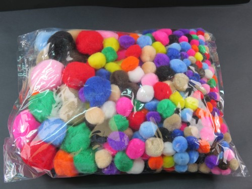 Assorted colorful pom poms in various sizes, perfect for creative crafting and DIY projects.