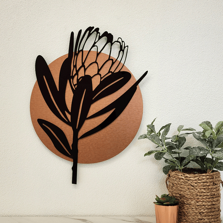 Stylish wall art featuring a gloss black Protea design and a brushed copper circle, ideal for modern decor.