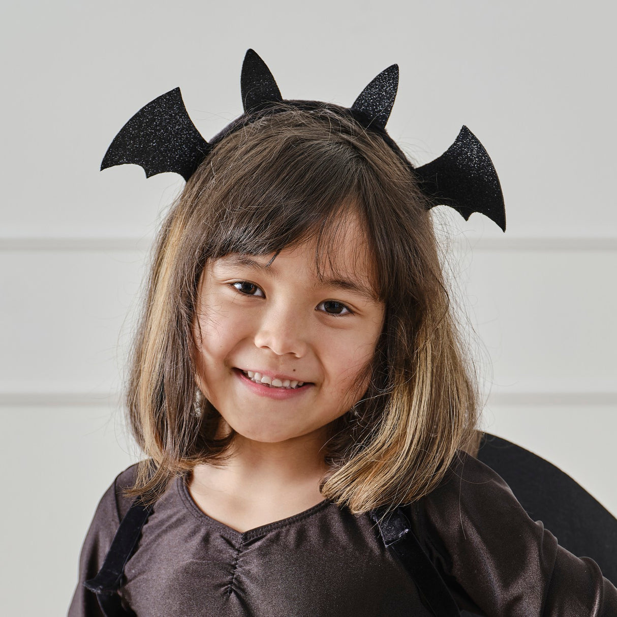 Black Sparkle Bat Headband with glittery wings, perfect accessory for Halloween costumes and themed parties. Eco-friendly packaging.