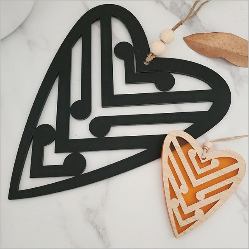 Black acrylic heart wall art featuring five koru designs, symbolizing growth and new beginnings, perfect for modern decor.