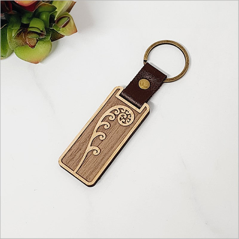 Eco-friendly bamboo keyring featuring a delicate frond design, perfect for stylishly organizing keys.