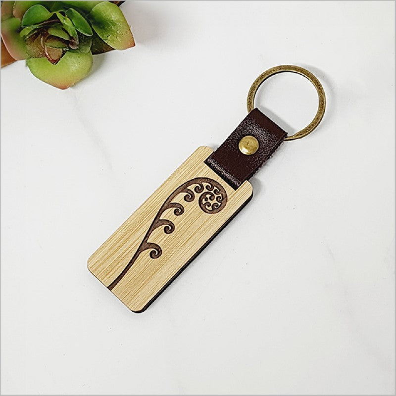 Eco-friendly bamboo keyring featuring a detailed frond design, perfect for stylish and sustainable organization.