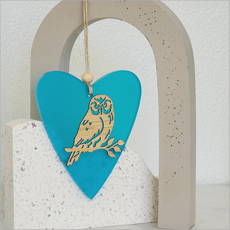 Teal heart-shaped hanging ornament featuring intricate laser-cut bamboo and satin acrylic, perfect for home decor.