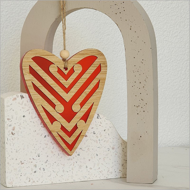 Red satin acrylic heart ornament with intricate Koru designs, perfect for holiday decor or a heartfelt gift.