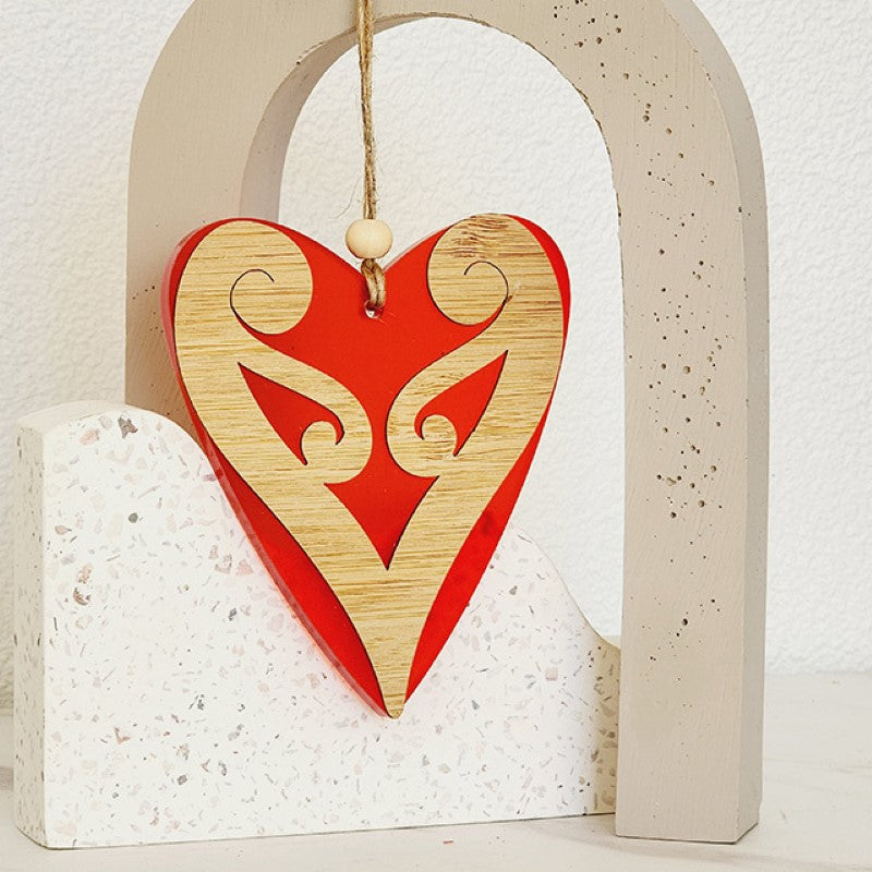 Red satin acrylic heart ornament with koru design, eco-friendly, perfect for holiday decor and gifting.