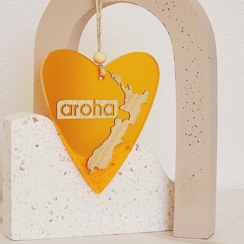 Vibrant orange heart-shaped hanging ornament made from satin acrylic, symbolizing love and warmth, perfect for home decor.
