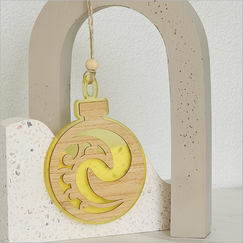 Vibrant yellow satin acrylic hanging ornament with Koru design, symbolizing new beginnings, perfect for holiday decor.