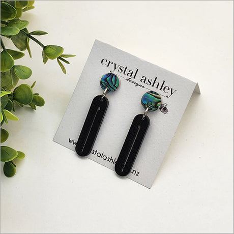 Long drop earrings featuring black wharare and unique paua shell, inspired by New Zealand's natural beauty.