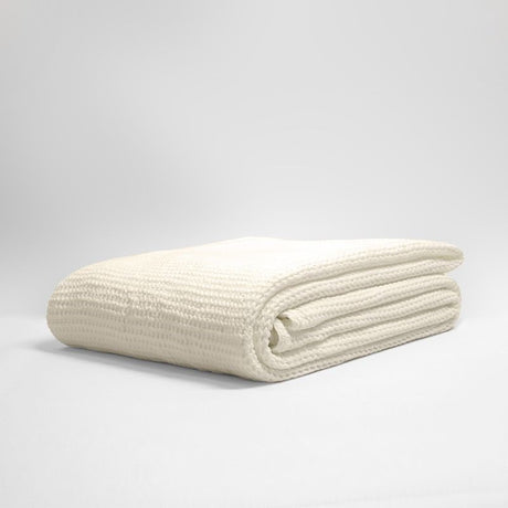 Stonewashed cotton blanket in soft stone color with a deep waffle texture, ideal for cozying up your space.