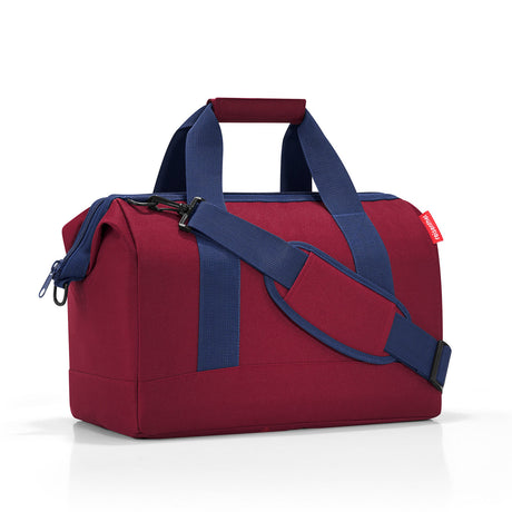 Versatile Reisenthel All Rounder M Bag in Dark Ruby, featuring sturdy zip, padded strap, and six pockets for organized storage.