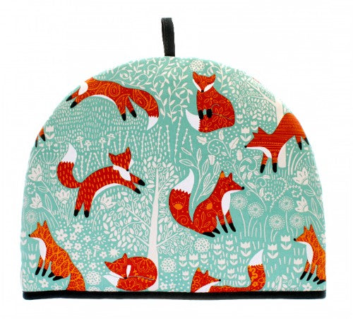 Whimsical tea cosy featuring a foraging fox on a duck egg shell background, designed to keep tea warm with stylish practicality.