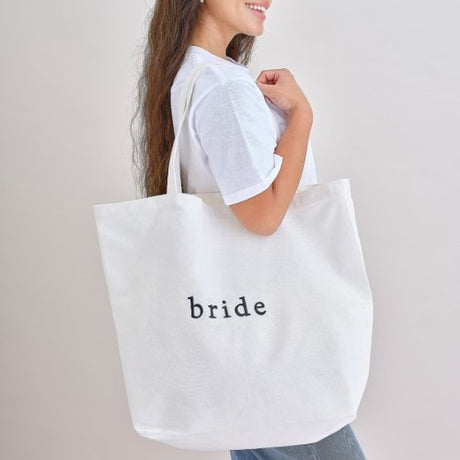Stylish white cotton tote bag for hen parties, spacious, durable handles, perfect for carrying essentials and gifts.