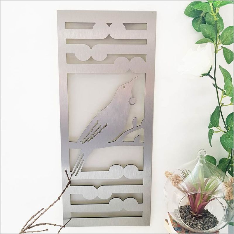 Brushed silver wall art panel featuring Tui bird and Koru fern, 55cm, ideal for indoor and outdoor decor.