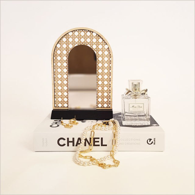 Elegant rattan earring stand with mirror, perfect for showcasing and organizing earrings on any dresser.