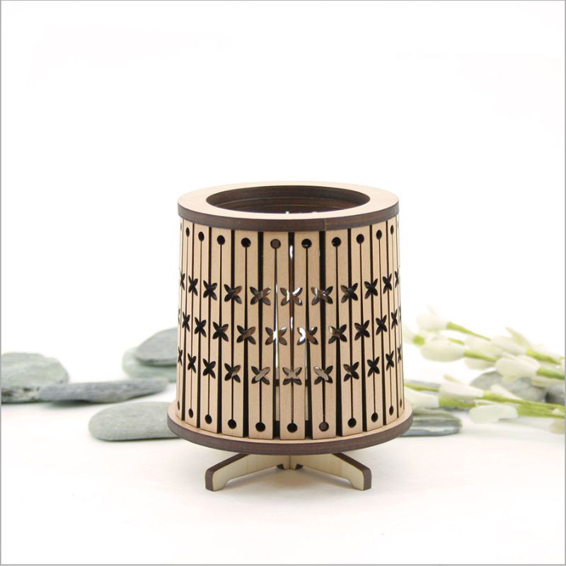 Round LED tealight holder in dark veneer with intricate design and color-changing LED candle, 8.5cm in diameter.
