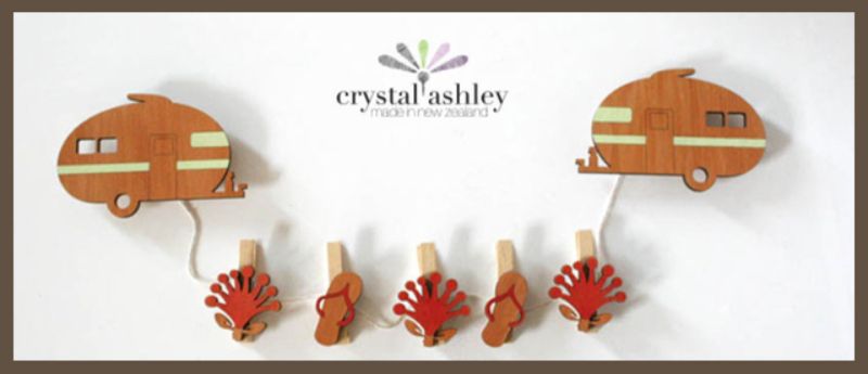 Colorful Rimu wood Caravan Art Pegs set featuring 3 Pohutukawa and 2 Jandal designs for hanging photos and notes.