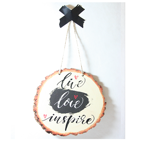 Wood slice wall art featuring the inspirational quote 'Live Love Inspire', crafted from eco-friendly pine veneer.