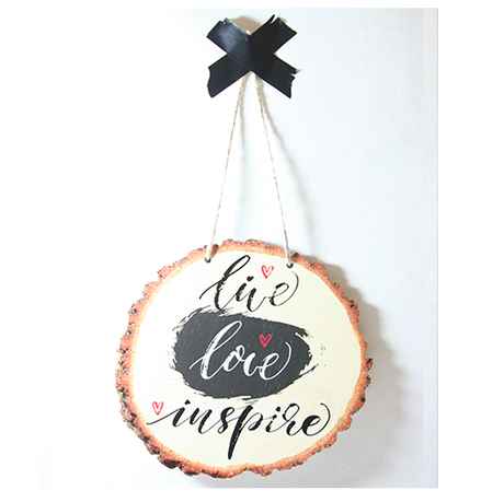 Wood slice wall art featuring the inspirational quote 'Live Love Inspire', crafted from eco-friendly pine veneer.