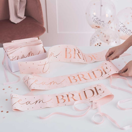 Pack of 6 pink and rose gold Team Bride sashes designed for hen parties, stylish and eye-catching for memorable celebrations.