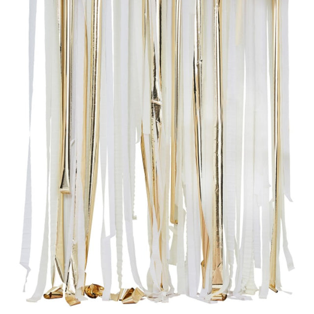 Gold metallic streamers backdrop with white and cream rolls, perfect for elegant party decor and photo booths.