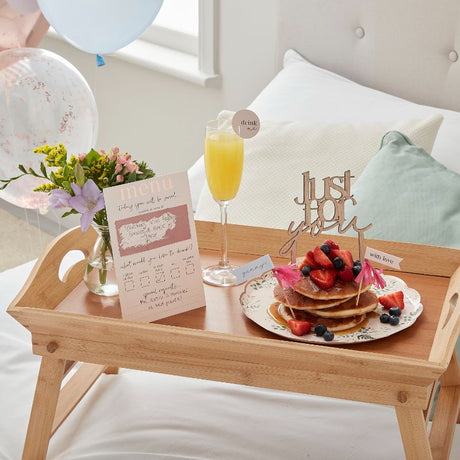 Customisable Breakfast in Bed Set featuring a scratch-to-reveal menu, drink topper, cake topper, cupcake toppers, and balloons.