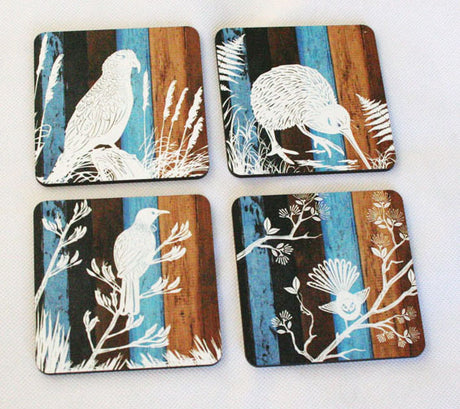 Set of four coasters featuring unique designs of New Zealand native birds on aged timber, perfect for Kiwiana decor.
