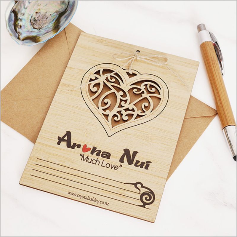 Eco-friendly bamboo postcard featuring Aroha Nui heart design, perfect for heartfelt messages and decorative use.