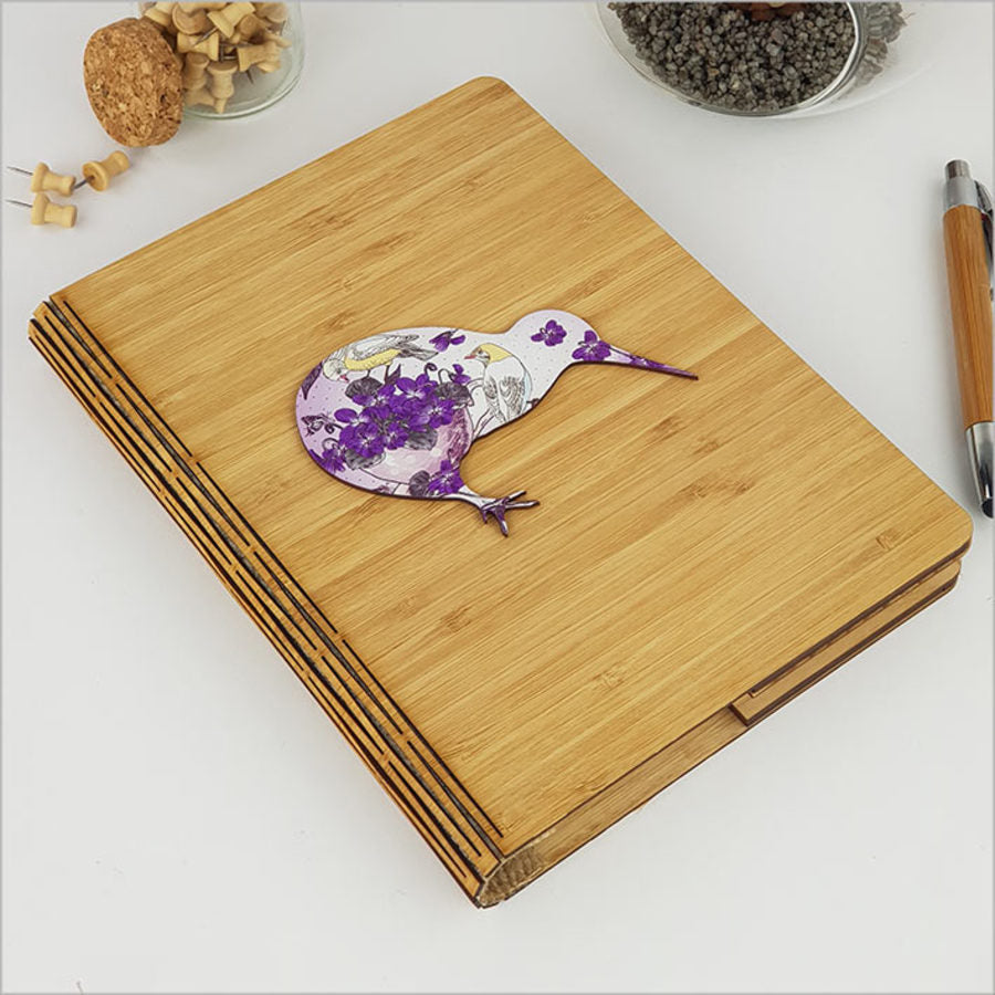 Eco-friendly bamboo journal with vibrant white floral kiwi print and 120 premium pages for writing and sketching.